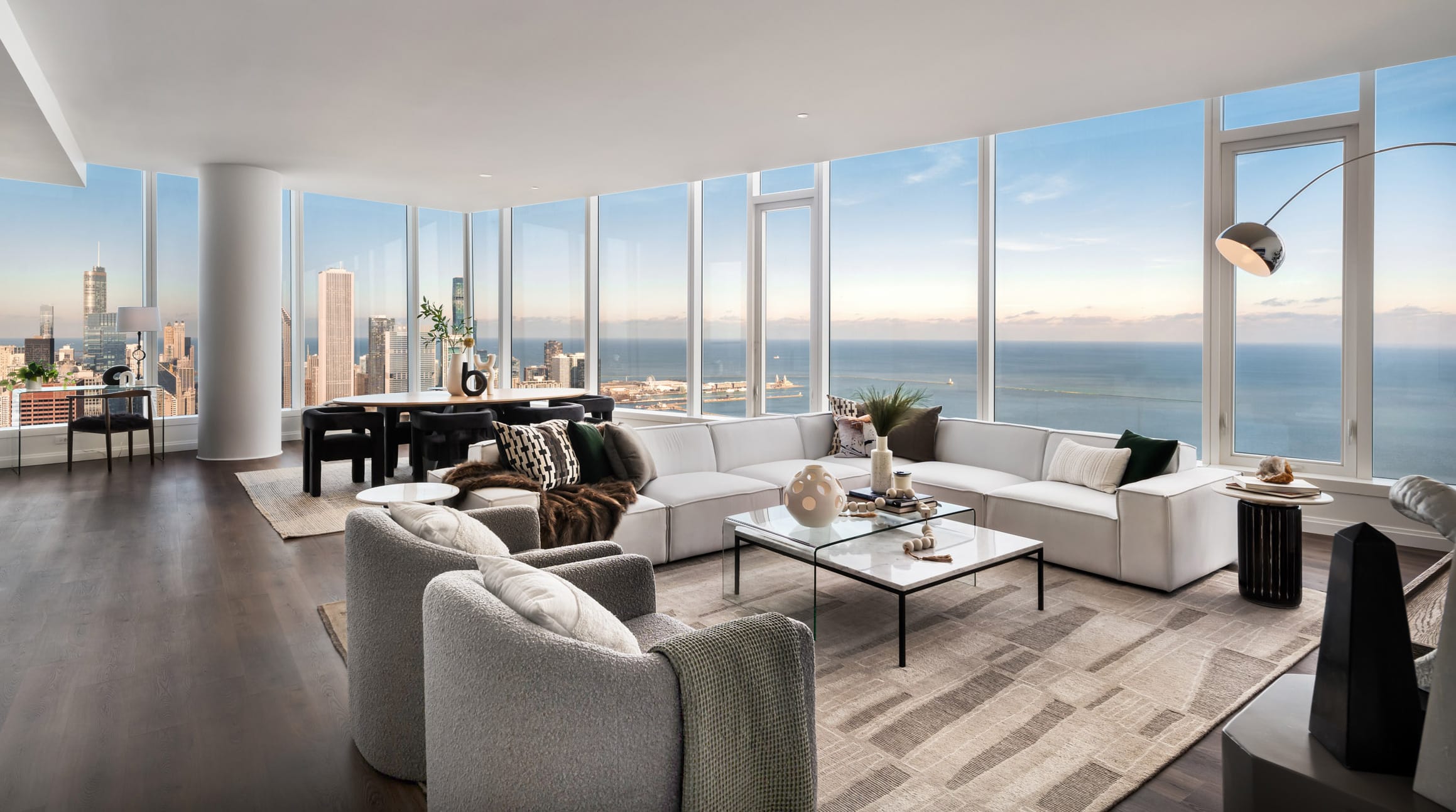 Penthouse Expansive Living and Dining Room with floor to ceiling windows showcasing expansive view of Lake Michigan and downtown Chicago skyline