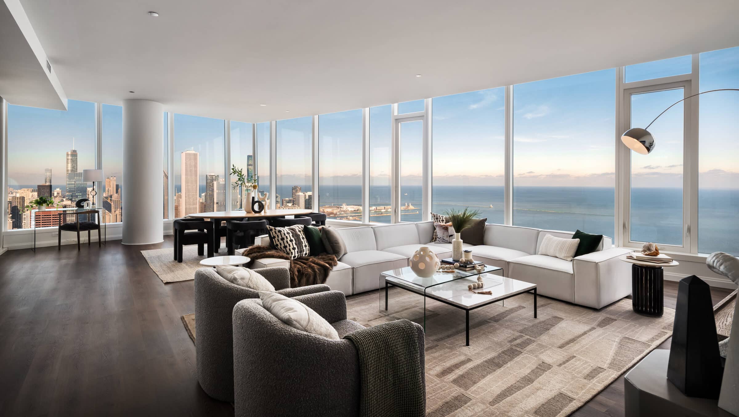 Penthouse Expansive Living and Dining Room with floor to ceiling windows showcasing expansive view of Lake Michigan and downtown Chicago skyline